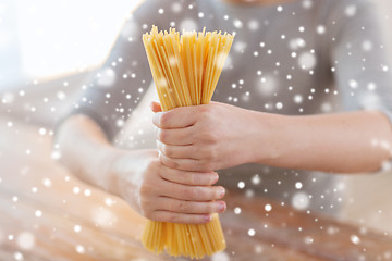 Image showing close up of female hands holding spaghetti pasta