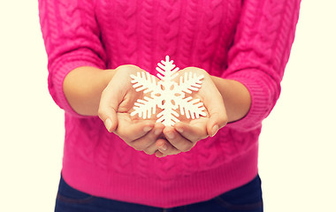Image showing close up of woman in sweater holding snowflake