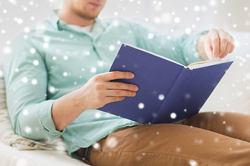 Image showing close up of man reading book at home