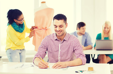 Image showing smiling fashion designers working in office