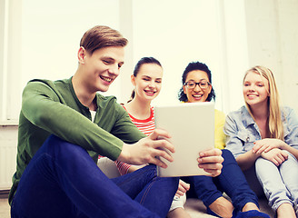 Image showing smiling students making picture with tablet pc