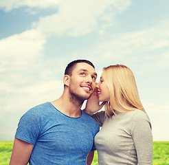 Image showing smiling girlfriend telling boyfriend secret