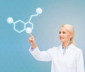 Image showing smiling female doctor pointing to molecule