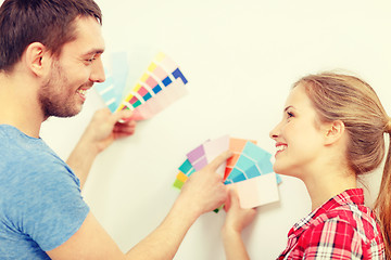 Image showing smiling couple looking at color samples at home