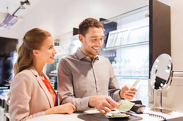 Image showing happy couple paying for purchase in store