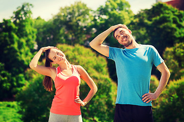 Image showing smiling couple stretching outdoors