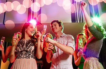 Image showing smiling friends with wine glasses and beer in club