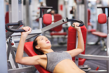 Image showing young woman exercising on gym machine