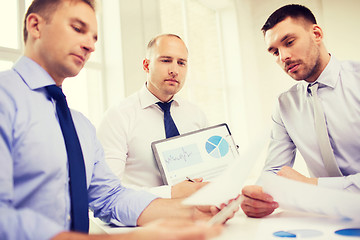 Image showing serious businessmen with papers in office