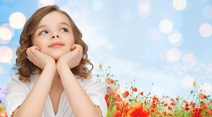 Image showing happy girl dreaming over poppy field background