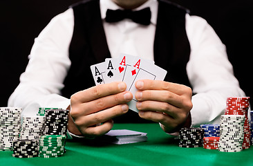 Image showing poker player with cards and chips at casino