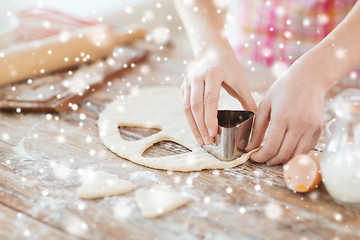 Image showing close up of woman hands making cookies from dough