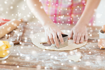 Image showing close up of hands making cookies from fresh dough