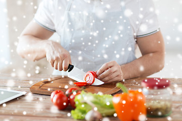 Image showing close up of man cutting vegetables with knife