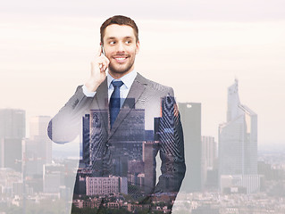 Image showing smiling young businessman over city background