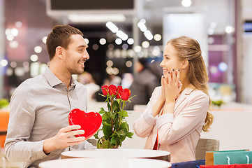 Image showing happy couple with present and flowers in mall