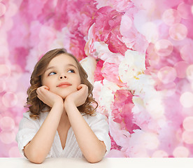 Image showing beautiful girl sitting at table and looking up