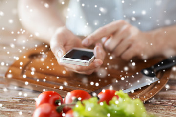 Image showing closeup of man reading recipe from smartphone