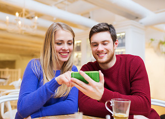 Image showing smiling couple with smartphone drinking tea