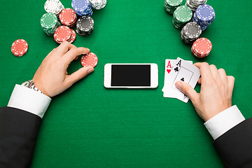 Image showing casino player with cards, smartphone and chips