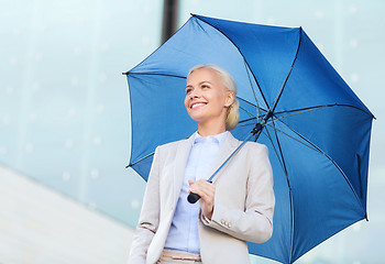 Image showing young smiling businesswoman with umbrella outdoors