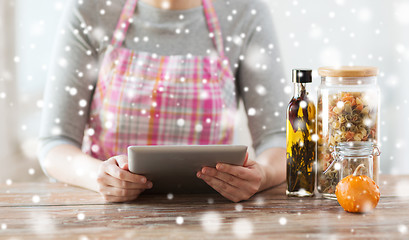 Image showing close up of woman reading recipe from tablet pc