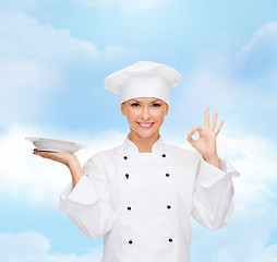 Image showing female chef with empty plate showing ok sign