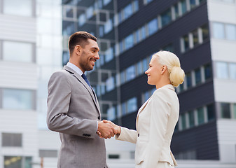 Image showing smiling businessmen standing over office building