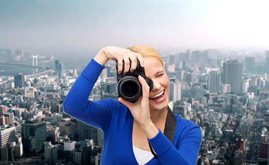 Image showing smiling woman taking picture with digital camera