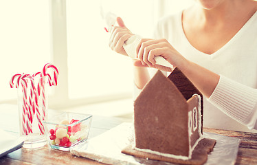 Image showing close up of woman making gingerbread houses