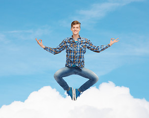 Image showing smiling young man flying in air