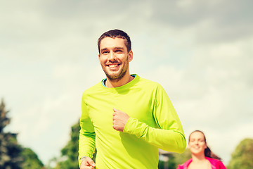 Image showing smiling couple running outdoors