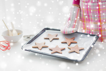 Image showing close up of woman with cookies on oven tray