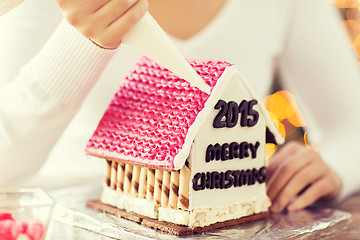 Image showing close up of woman making gingerbread houses