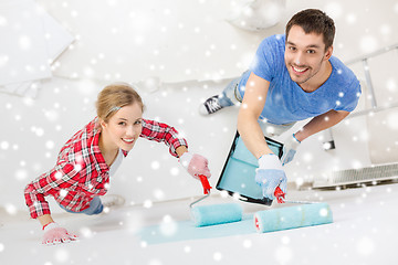 Image showing smiling couple with roll and tray painting wall