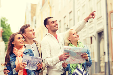 Image showing group of smiling friends with city guide and map