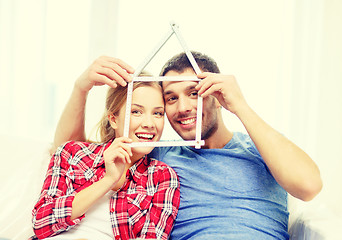 Image showing smiling couple with house from measuring tape