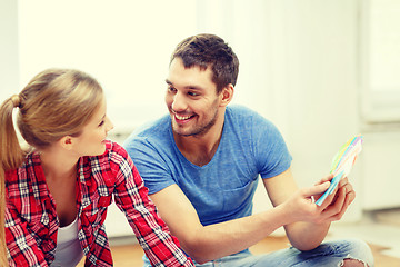 Image showing smiling couple looking at color samples at home