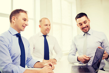 Image showing smiling businessmen having discussion in office