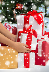 Image showing close up of woman with gifts and christmas tree