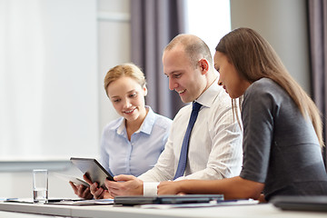 Image showing smiling business people with tablet pc in office