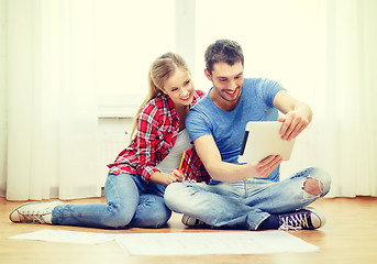 Image showing smiling couple looking at tablet pc at home