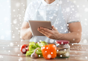 Image showing closeup of man reading recipe from tablet pc