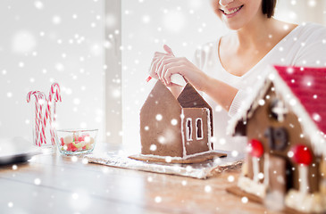 Image showing close up of woman making gingerbread houses