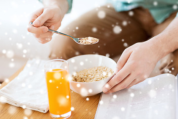 Image showing close up of man with magazine eating breakfast