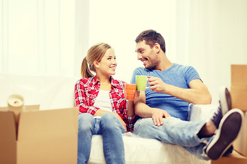 Image showing smiling couple relaxing on sofa in new home