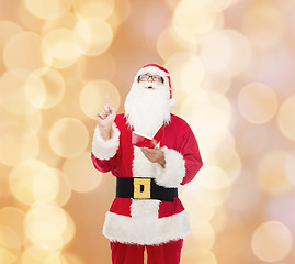 Image showing man in costume of santa claus with notepad