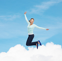 Image showing smiling young woman jumping in air