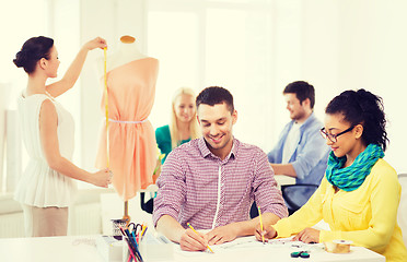 Image showing smiling fashion designers working in office