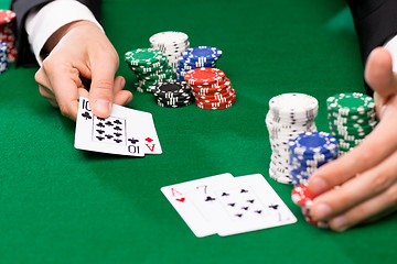 Image showing poker player with cards and chips at casino